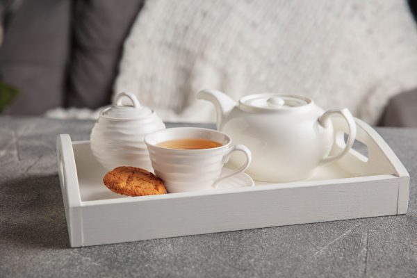 set-da-te-bianco-e-torte-sulla-tavola-di-legno-grigio-vassoio-in-legno-bianco-con-tazze-teiera-e-luci-ghirlande